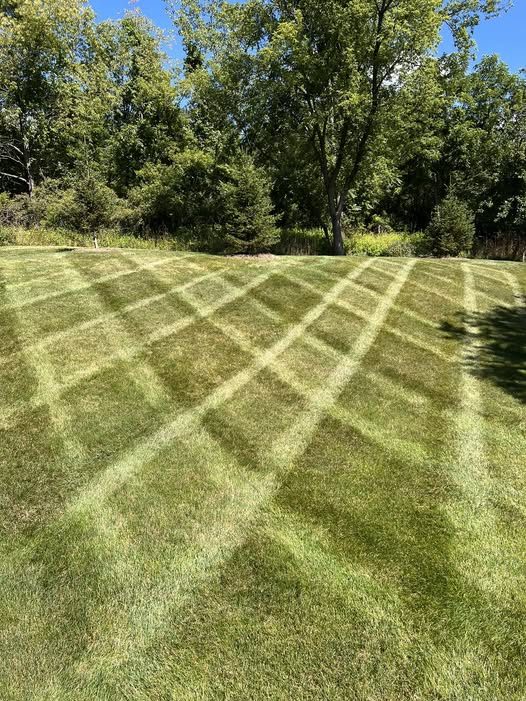 A freshly mowed lawn with a clean diagonal crosshatch stripe pattern